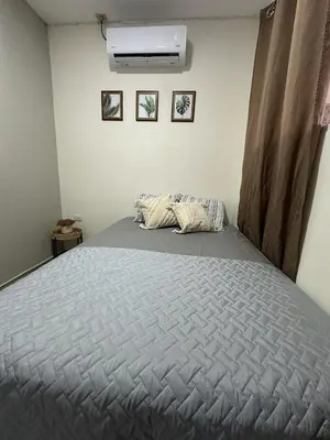 a bedroom with a large bed with a blanket on it at Apartamento C Fuertevali in San Salvador