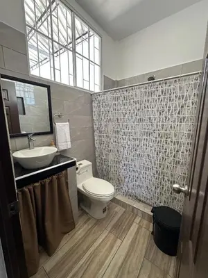 a bathroom with a toilet and a sink and a mirror at Apartamento C Fuertevali in San Salvador