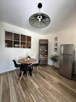 a dining room with a table and a refrigerator at Apartamento C Fuertevali in San Salvador