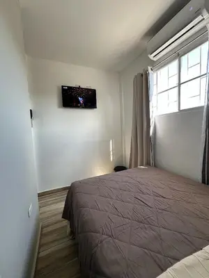 a bedroom with a bed and a television on the wall at Apartamento C Fuertevali in San Salvador