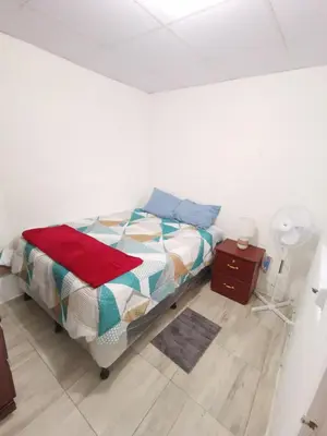 a bedroom with a bed and a table with a fan at Casa céntrica en zona privada in Las Delicias