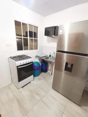a kitchen with a stove and a stainless steel refrigerator at Casa céntrica en zona privada in Las Delicias