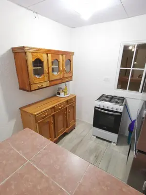a kitchen with wooden cabinets and a stove at Casa céntrica en zona privada in Las Delicias