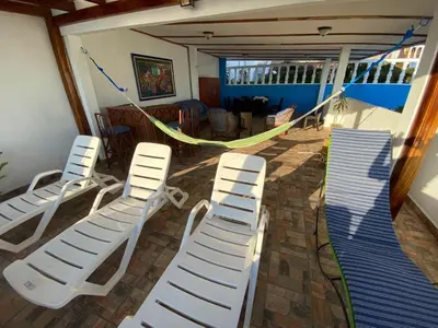 a group of lounge chairs and a hammock in a room at Mar y Cielo Beach House in Tamanique