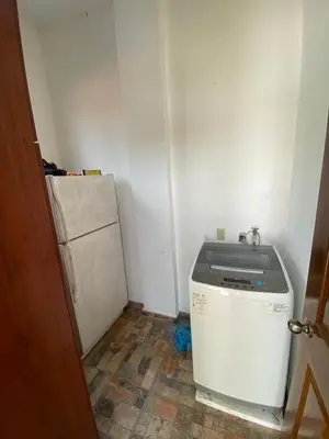 a small kitchen with a washer and a refrigerator at Mar y Cielo Beach House in Tamanique