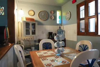 a kitchen with a table and chairs and plates on the wall at Artful and Quiet Pause in Santa Tecla and BBQ garden in Nueva San Salvador