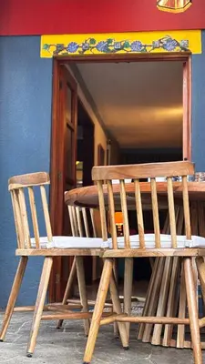 a wooden bench sitting in front of a table at Artful and Quiet Pause in Santa Tecla and BBQ garden in Nueva San Salvador
