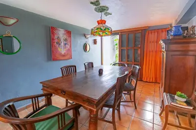 a dining room with a wooden table and chairs at Artful and Quiet Pause in Santa Tecla and BBQ garden in Nueva San Salvador