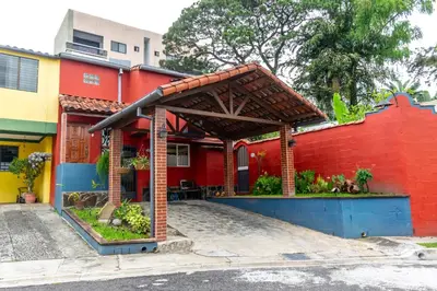 a red house with a red wall at Artful and Quiet Pause in Santa Tecla and BBQ garden in Nueva San Salvador