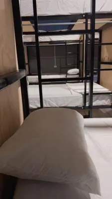 two bunk beds in a room with a pillow at Milos Hostel in Santa Ana