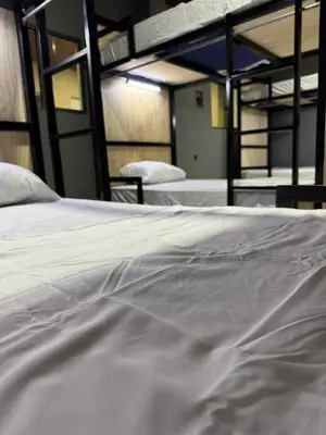 a close up of a white bed in a room at Milos Hostel in Santa Ana