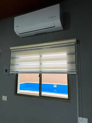 a window with a white blind in a room at Milos Hostel in Santa Ana