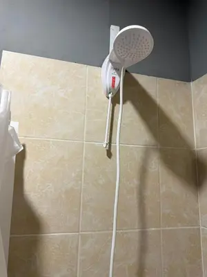 a shower head in a corner of a bathroom at Milos Hostel in Santa Ana