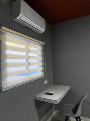 a room with a desk and a chair and a window at Milos Hostel in Santa Ana