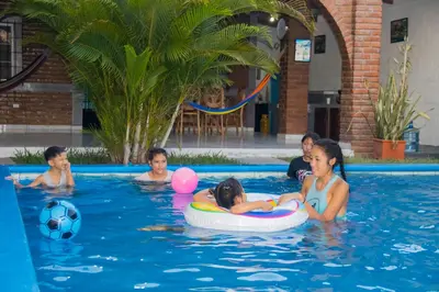 a group of children playing in a swimming pool at Coco Cabana en Playa San Diego in San Diego