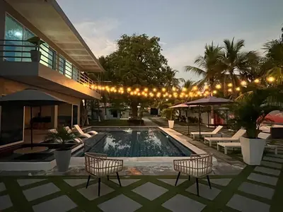 a swimming pool with chairs and a building at Kosta Brava Hotel y Restobar in El Majahual