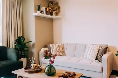 a living room with a white couch and a table at NEW Cozy&Modern Apt 30min from SurfCity in Hacienda Plan de La Laguna