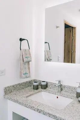 a bathroom counter with a sink and a mirror at NEW Cozy&Modern Apt 30min from SurfCity in Hacienda Plan de La Laguna