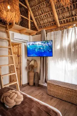 a living room with a tv on a wall at hotel nativo san blas in Playa San Blas