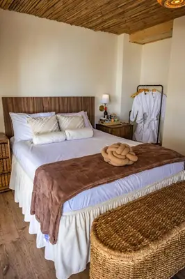 a bedroom with a large bed with a wooden headboard at hotel nativo san blas in Playa San Blas