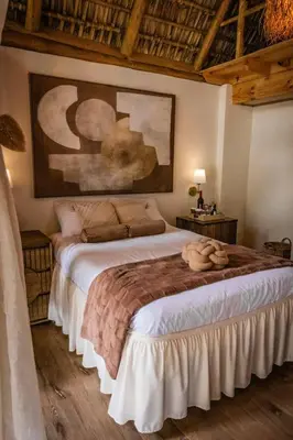 a bedroom with a large bed with a painting on the wall at hotel nativo san blas in Playa San Blas