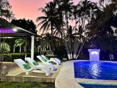 a group of white lounge chairs next to a pool at Game Room • Pool • Fire Pit • Resort Access in Los Cóbanos