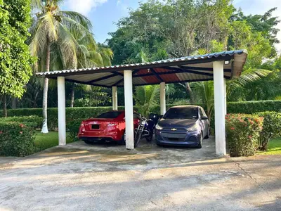 two cars parked in a parking lot with a roof at Game Room • Pool • Fire Pit • Resort Access in Los Cóbanos
