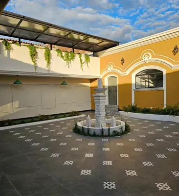 a building with a fountain in the courtyard at Remfort Hotel Antigua in Santa Ana
