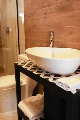 a bathroom with a white sink on a counter at Remfort Hotel Antigua in Santa Ana
