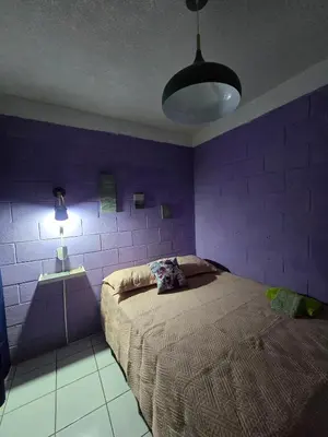 a purple bedroom with a bed and a lamp at central and private apartment in Santa Ana