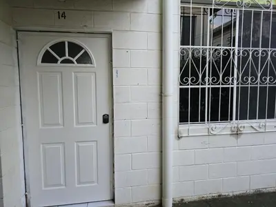a white door next to a brick building at central and private apartment in Santa Ana