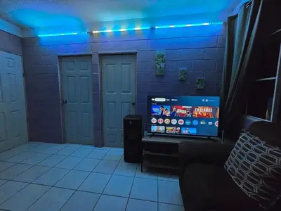 a living room with a tv and blue lights at central and private apartment in Santa Ana