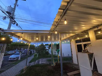 a pergola with lights on the side of a house at central and private apartment in Santa Ana