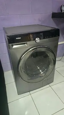 a washing machine sitting on a tile floor at central and private apartment in Santa Ana