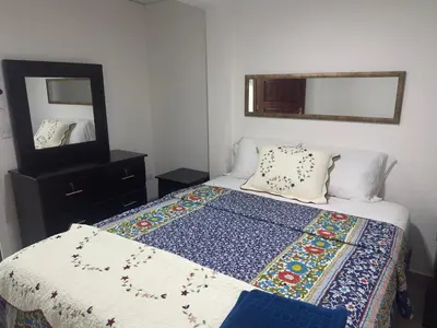 a bedroom with a bed with a quilt and a mirror at Atractivo apartamento in San Salvador