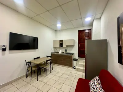 a living room with a table and a kitchen at Atractivo apartamento in San Salvador
