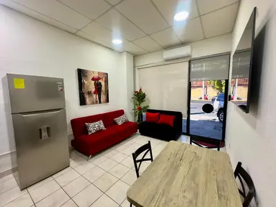 a living room with a table and a red couch at Atractivo apartamento in San Salvador
