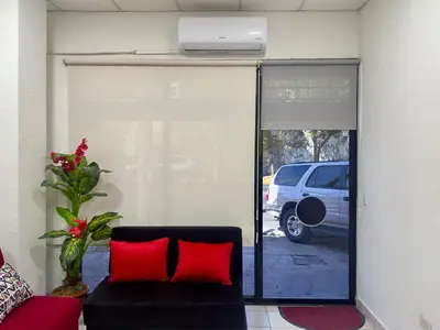 a living room with a couch and a window with a car at Atractivo apartamento in San Salvador