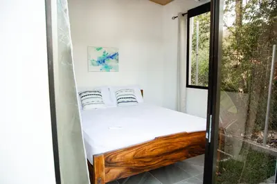 a bed in a small room with a window at Villa Palmarcito in El Zonte