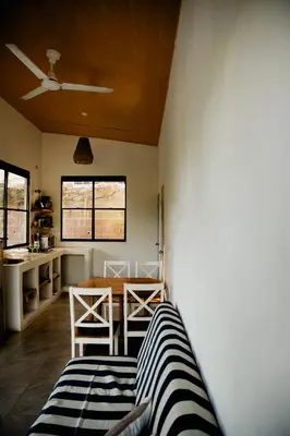 a room with a table and chairs and a kitchen at Villa Palmarcito in El Zonte