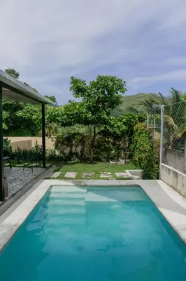 a swimming pool with blue water in a yard at Villa Palmarcito in El Zonte