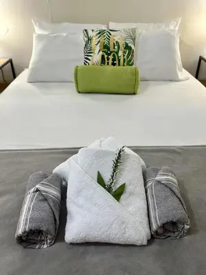 a bed with towels and a plant on it at Pool • Game Room • Fire Pit • Resort Access in Los Cóbanos