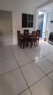 a dining room with a table and chairs on a tiled floor at Hogar cálido