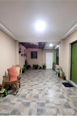 an empty living room with a couch and some plants at Hogar cálido