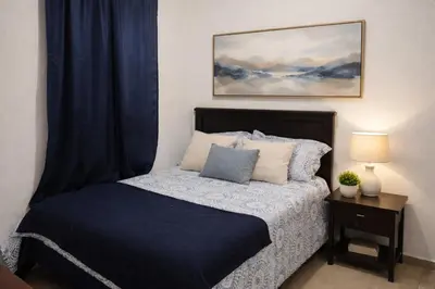 a bedroom with a bed with a blue comforter at Casa Socorrito in Ahuachapán