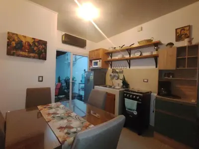 a kitchen and dining room with a table and a stove at Casa Socorrito in Ahuachapán