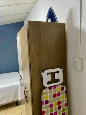 a room with a locker and a suitcase in a room at Los Poca, Entire Home near Stadiums & Malls, San Salvador in San Salvador