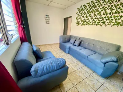 a living room with a blue couch and couches at Los Poca, Entire Home near Stadiums & Malls, San Salvador in San Salvador