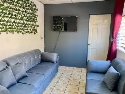 a living room with a couch and a tv at Los Poca, Entire Home near Stadiums & Malls, San Salvador in San Salvador