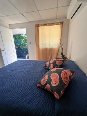 a bedroom with a blue bed with two pillows on it at Hostal Proceres in San Salvador